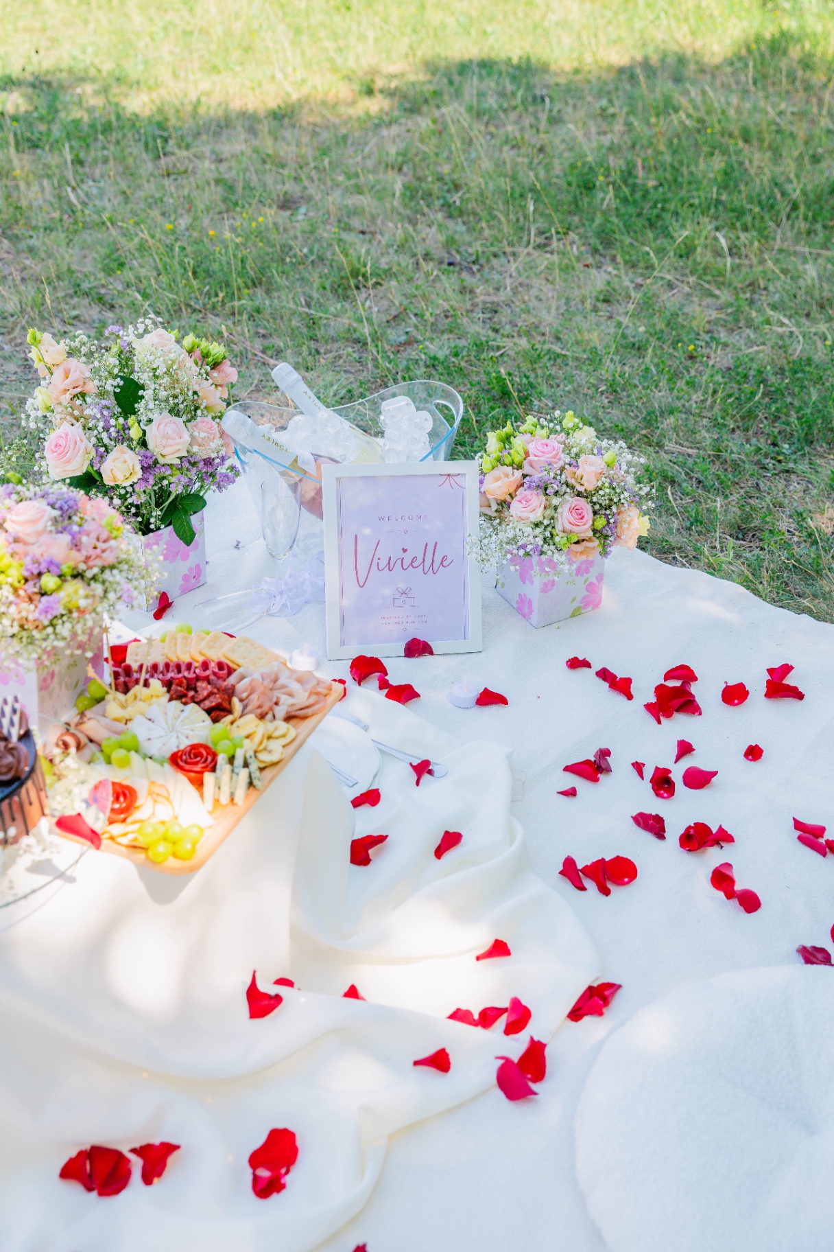 Personalised Vivielle welcome sign with charcuterie board, champagne bucket and rose petals — Budapest luxury picnic