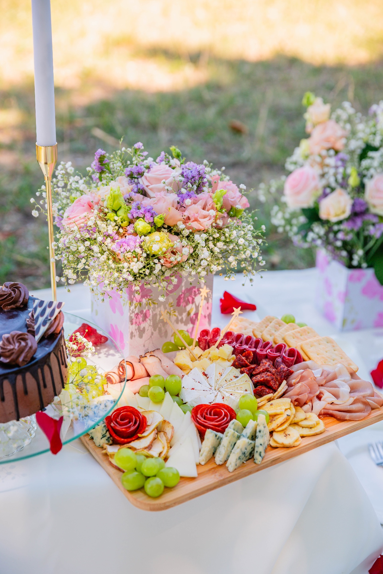 Luxury picnic tablescape with pastel floral centerpiece, chocolate drip cake and gourmet charcuterie board — Vivielle Events Budapest