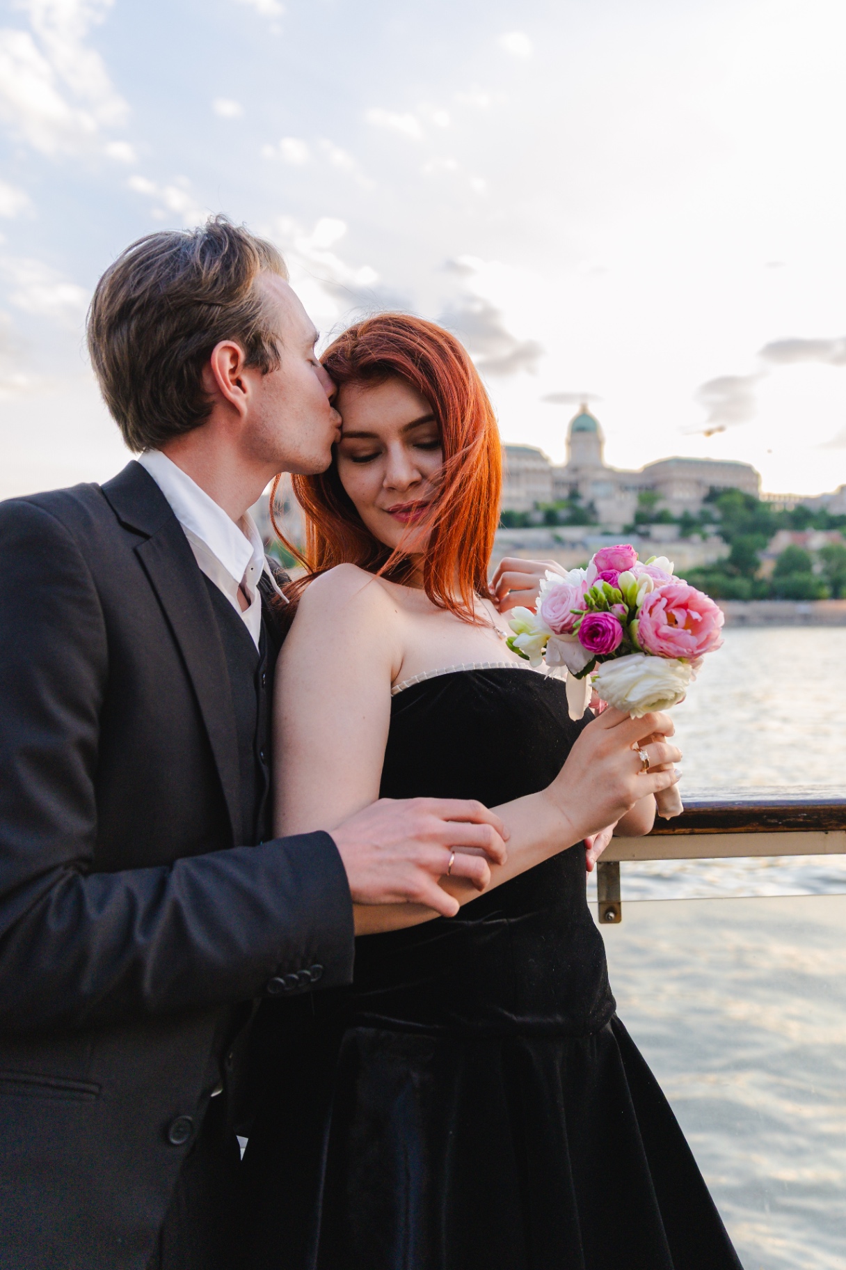 Couple kissing by the Danube with Buda Castle behind