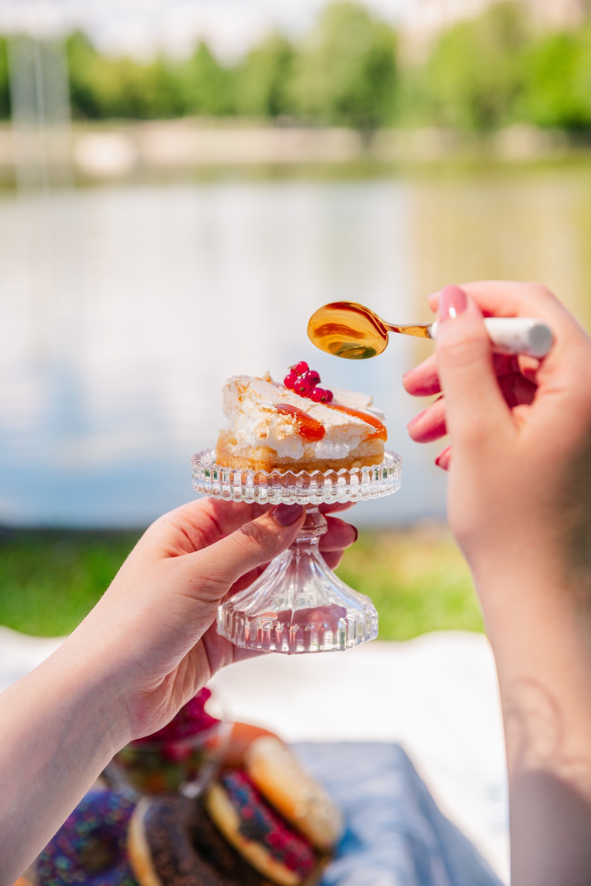 Milestone celebration in Budapest — hands holding a mini cake by the riverside