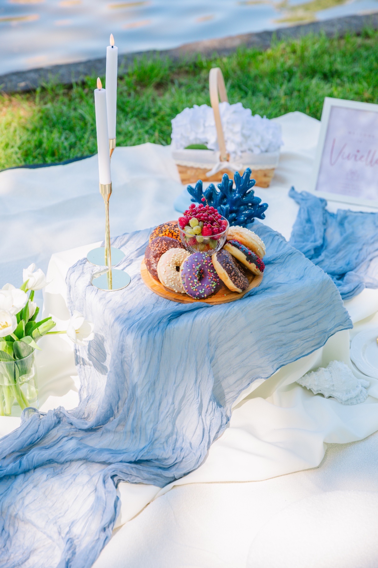 Coastal-themed luxury picnic spread in Budapest with donuts, fruit and blue coral accents
