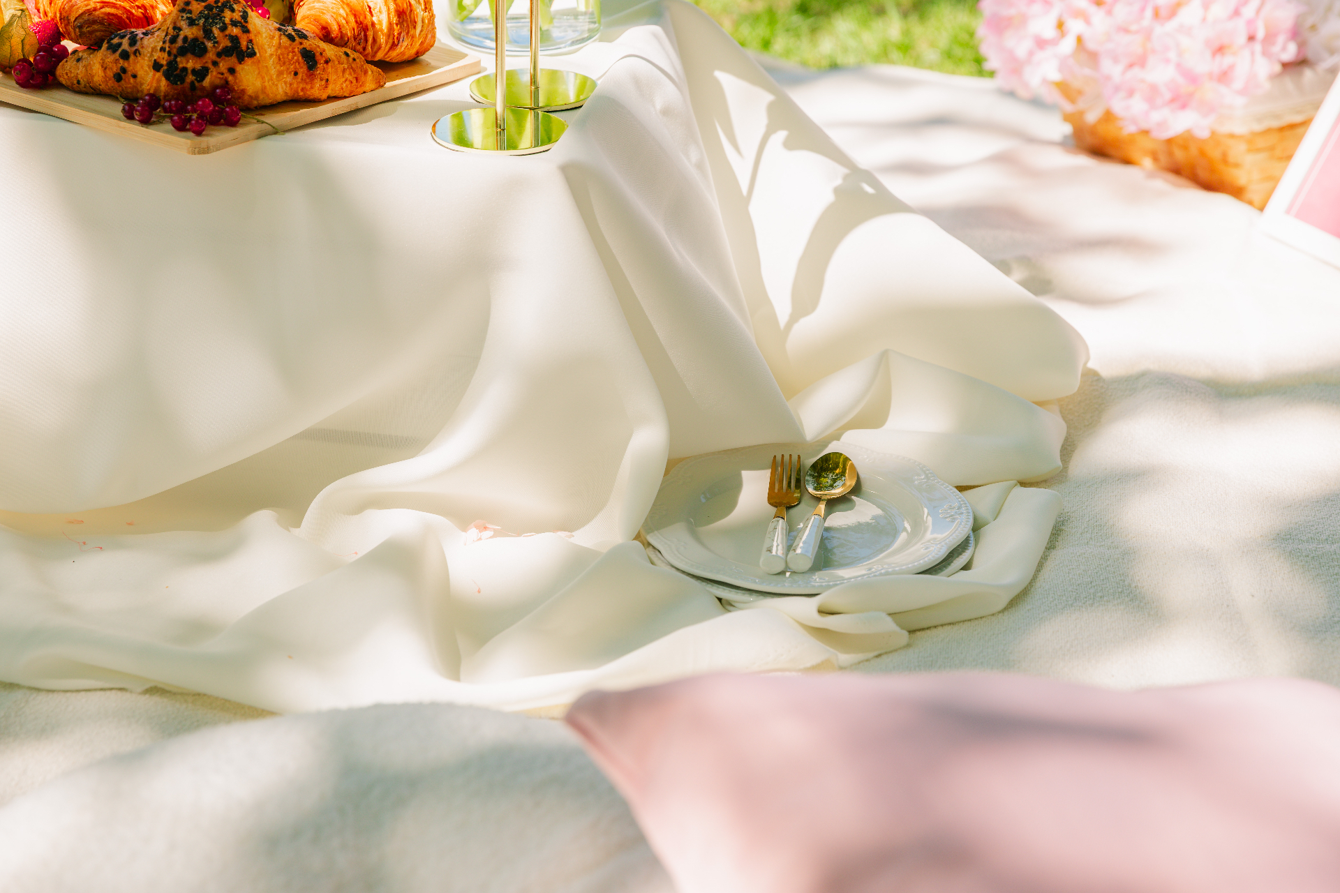 Premium milestone event styling Budapest — soft cream drapery with vintage plates and gold cutlery