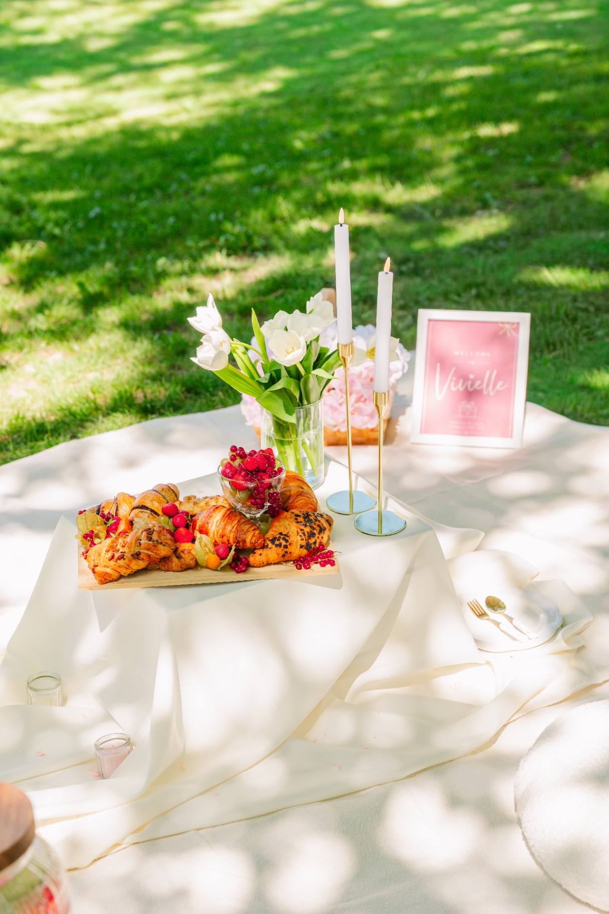 Sunlit luxury picnic in Budapest with croissant board, white tulips and gold candlesticks