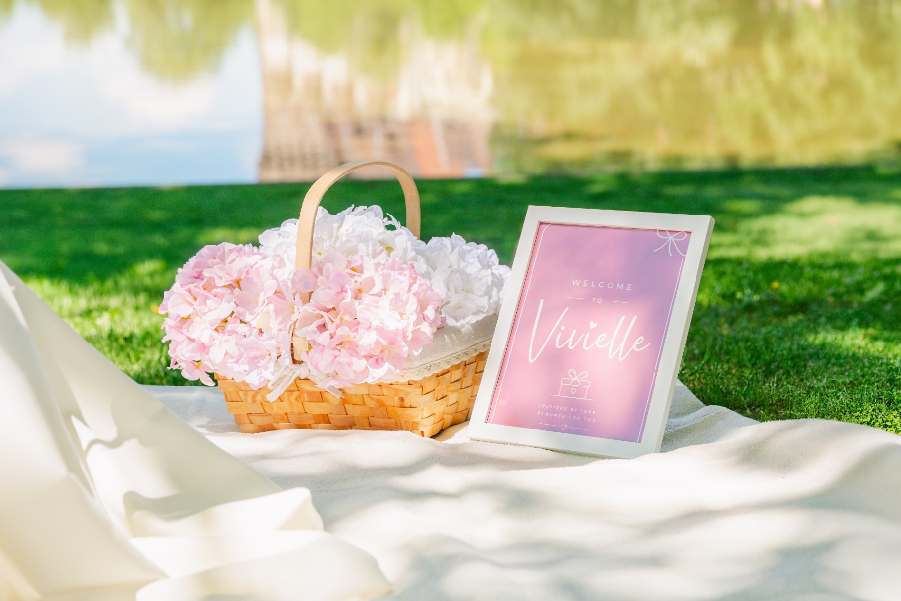 Lakeside Vivielle Events luxury picnic in Budapest with pink hydrangea basket and welcome sign