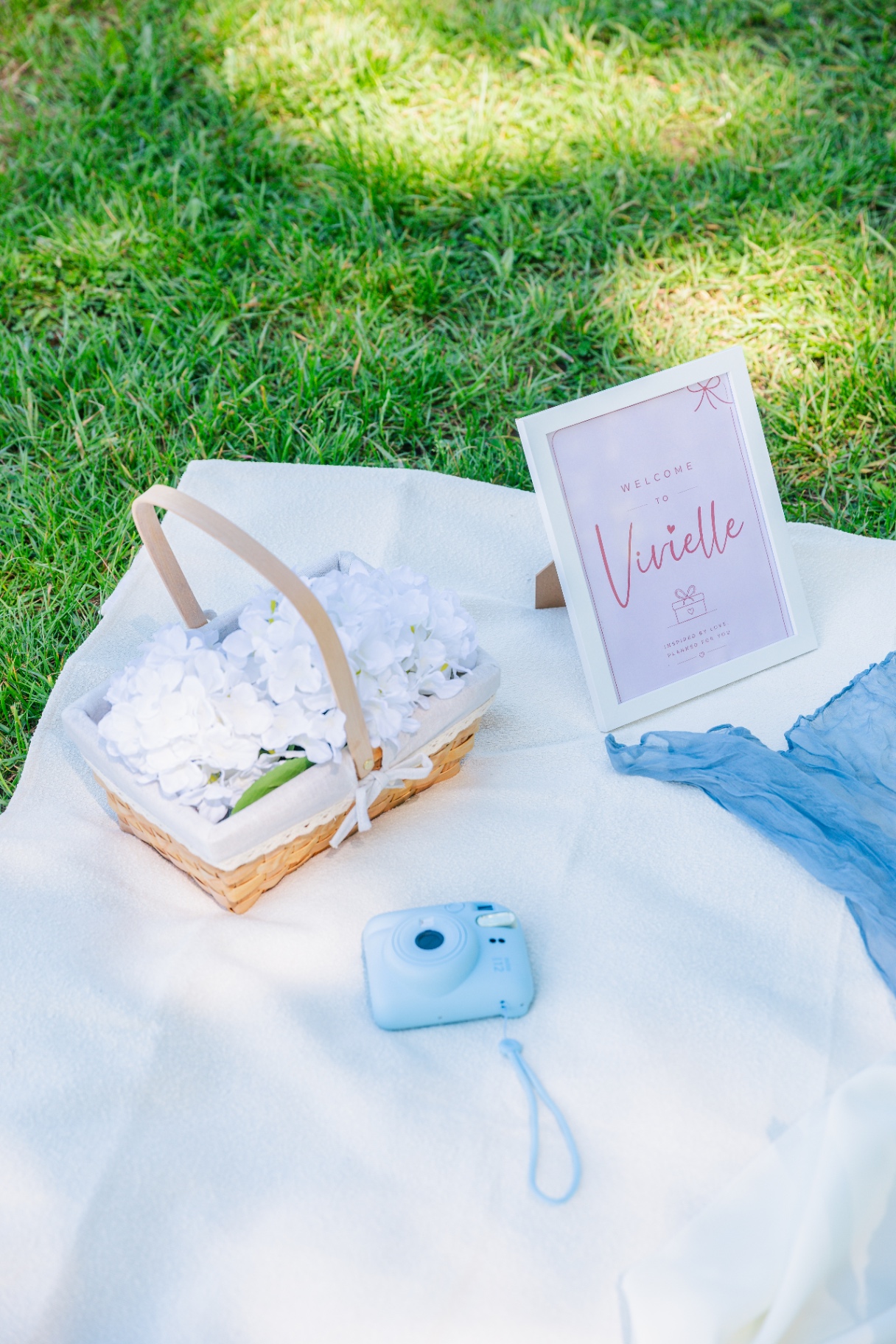 Vivielle Events luxury picnic Budapest detail with pastel polaroid camera and floral basket